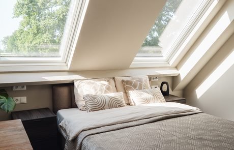 Slaapkamer met groot dakraam en uitzicht op de weilanden