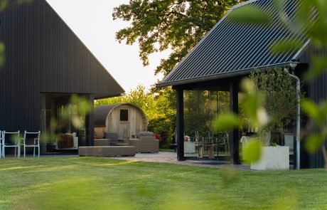 Tuin met barrelsauna en tuinkamer in de avond - B&B Smalle Ee