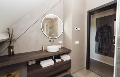 Eigen badkamer met waskom, ronde spiegel en badjas