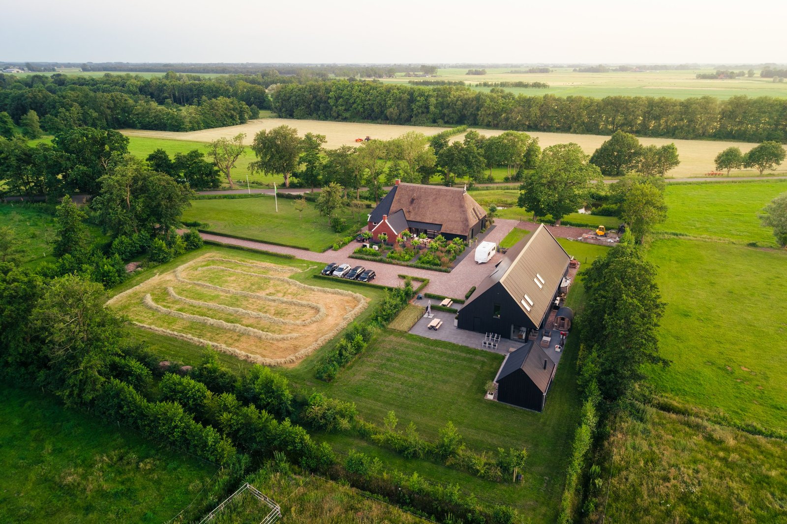 Luchtfoto van de herbouwde boerderij en de schuurwoning op het erf