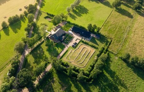 Luchtfoto van het erf van 1,1 hectare met boerderij en schuurwoning