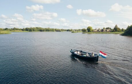 De sloep Black Out vaart over het Friese water, gezien vanuit de lucht