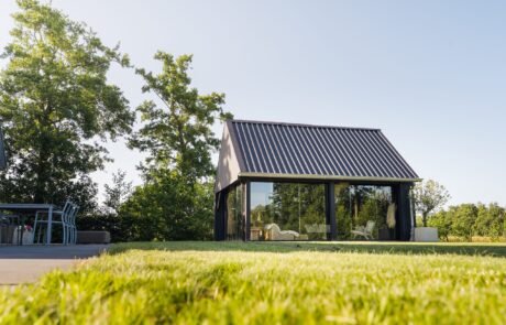 Vrijstaande tuinkamer met glazen schuifwanden die helemaal open kunnen